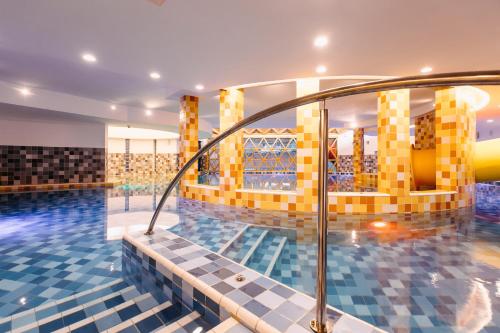索瓦塔HOTEL CRYSTAL WELLNESS & SPA superior的游泳池拥有黄色和蓝色的瓷砖
