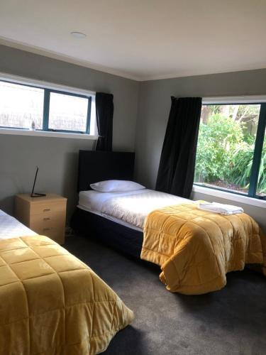 帕拉帕拉乌姆海滩Observation Holiday Home的一间卧室设有两张床和窗户。