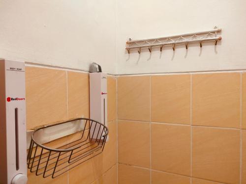 日惹RedDoorz near Kampus UNY Jogja的带淋浴的浴室,墙上装有篮子