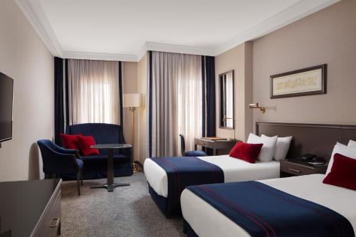 伊斯坦布尔西瓦希尔会议中心大酒店的酒店客房,配有两张床和椅子