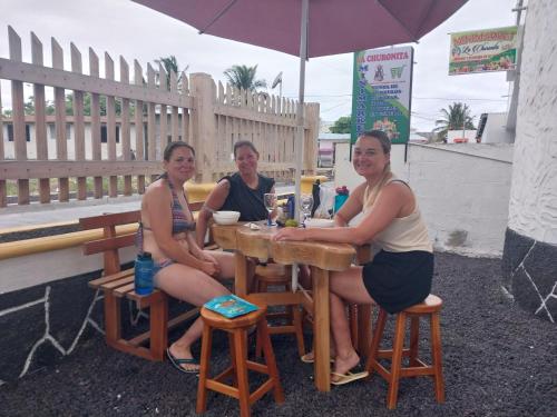 比亚米尔港La Casa de Joel的坐在桌子下的一个伞下,三个女人