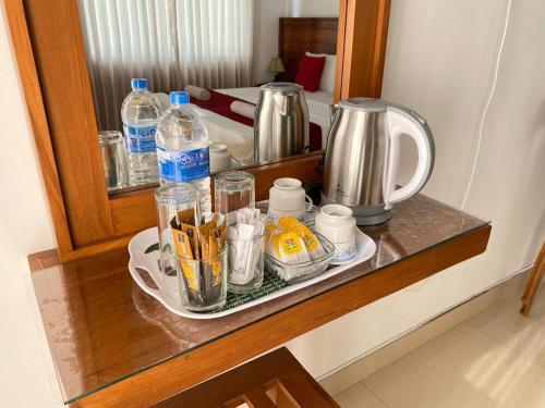 康提莎尼坎迪旅馆的桌子上装有杯子和水瓶的架子