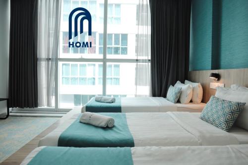 哥打京那巴鲁Homi Breeze 和逸微风的酒店的客房内设有两张床,窗户上有一个软木标志