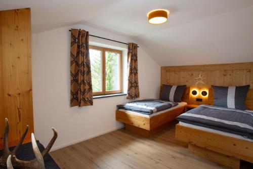 普夫龙滕Alpinchalet的一间卧室设有两张床和窗户。