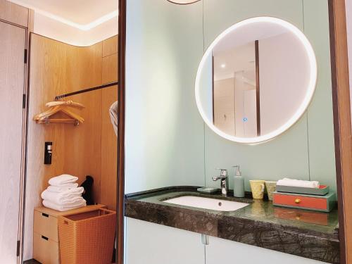 杭州之江印象君亭酒店(杭州转塘中国美院店）的一间带水槽和镜子的浴室