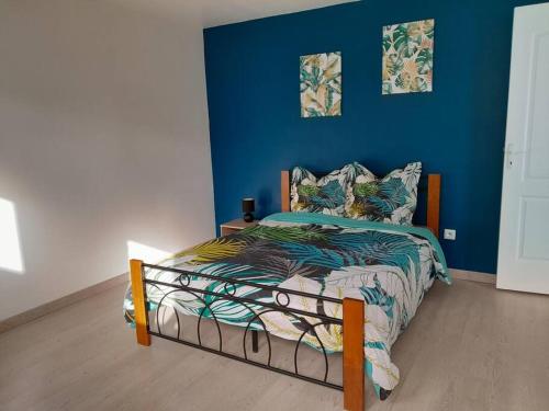 圣勒Maison de vacances Leu ti coin des ô的一间卧室配有一张蓝色墙壁的床