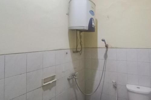 玛琅Hotel Malang near Alun Alun Malang RedPartner的浴室设有淋浴,墙上设有饮水机