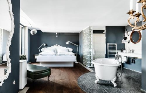 维也纳维也纳市中心费迪南德大酒店的卧室配有白色的床和浴缸