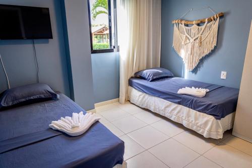 普拉亚多Refúgio na Praia do Forte的蓝色墙壁客房的两张床