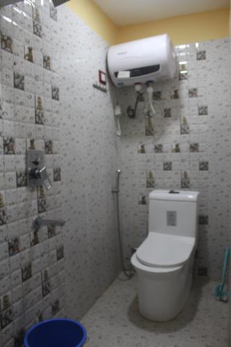 BirtamodHotel Giggle Coast Restro and Lodge的一间带卫生间的浴室和墙上的纸箱