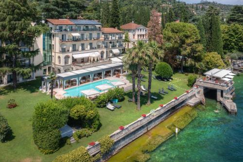 加尔多内-里维耶拉卡普里别墅酒店的享有带游泳池和河流的房屋的空中景致