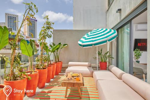 卡萨布兰卡Stayhere Casablanca - Gauthier 2 - Contemporary Residence的一个带植物的庭院、一张沙发和一把伞