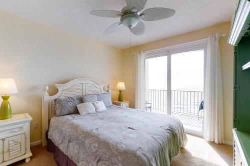 佩尔迪多基Windemere 0805的一间卧室配有一张带吊扇和窗户的床。