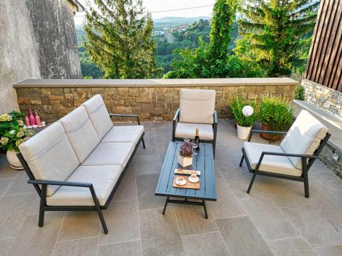 斯马尔诺Suites DANICA的庭院配有两把椅子、一张桌子和一张沙发