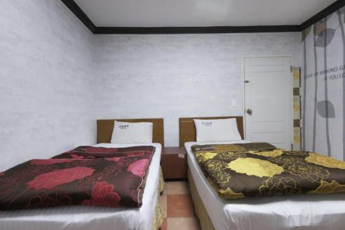 大邱城市之梦汽车酒店的两张睡床彼此相邻,位于一个房间里