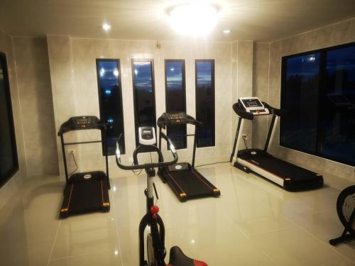 Ban Kut Ngongกานต์สินี อินน์ รีสอร์ท的客房设有带机器和窗户的健身房