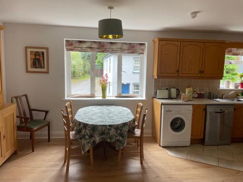 格伦加里夫Garinish Court Maisonette的厨房配有桌椅和窗户。