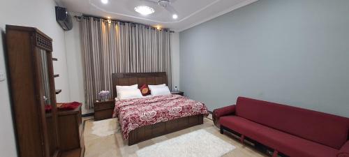 伊斯兰堡AIRWAYS B&B Islamabad Free Airport Pick and Drop的一间卧室配有一张床和一张红色的沙发