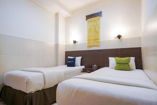 PondoklangUrbanview Hotel 58 Bintaro by RedDoorz的酒店客房设有两张床和窗户。