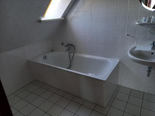 鲁博斯托夫加斯特豪斯族姆若思博格酒店的带浴缸和盥洗盆的浴室
