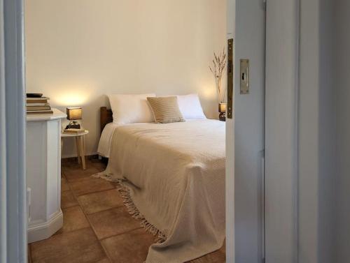 依拉佩特拉Santa Maria - Seaside Serenity的一间卧室配有一张床和一张带台灯的桌子