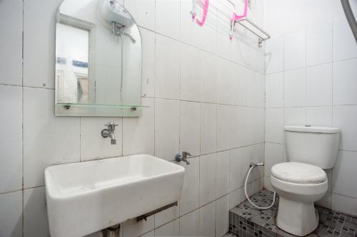 雅加达RedDoorz Syariah near PGC Cililitan的一间带水槽、卫生间和镜子的浴室