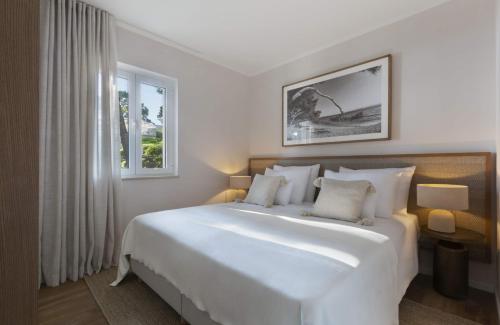 布雷拉Villa Berulia的卧室设有一张白色大床和一扇窗户。
