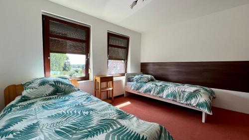 伊策霍Haus - mit Grundstück und Privatparkplatz的一间卧室设有两张床和窗户。