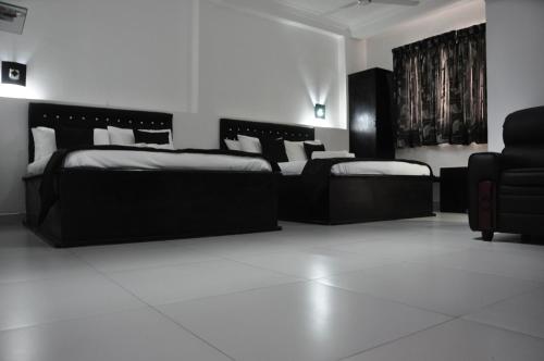亭可马里维拉酒店的一间设有两张床和椅子的房间