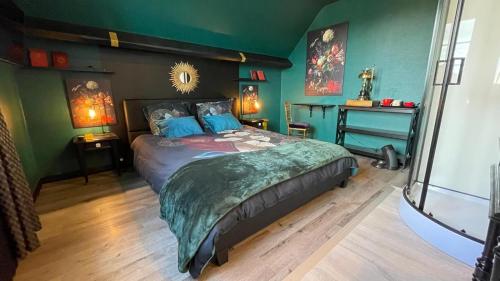 Saint-Germain-du-Corbéisles nuits victoriennes的一间设有一张大床的卧室,位于带绿色墙壁的房间