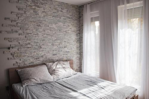 福纽德Butik Apartmanház的卧室内的一张床位,卧室设有砖墙