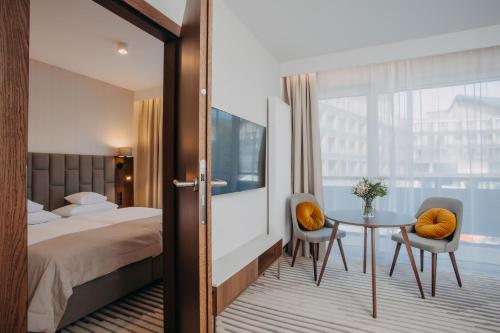希维拉杜夫-兹德鲁伊Elements Apartments的酒店客房带一张床、一张桌子和椅子