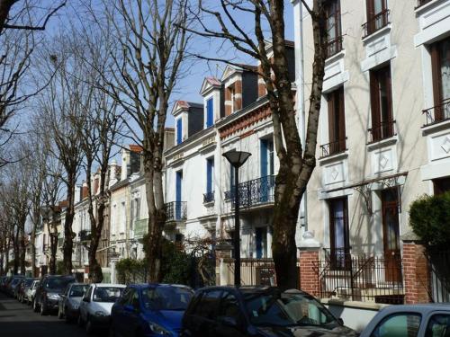 维希Appartement au calme T3 RDC - Quartier de France的街道上,有汽车停在建筑前