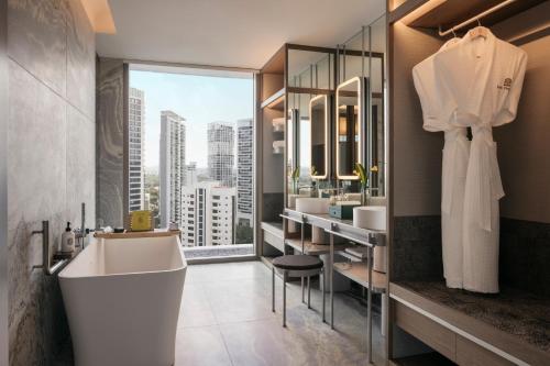 新加坡乌节泛太平洋酒店的一间带白色浴缸和大窗户的浴室