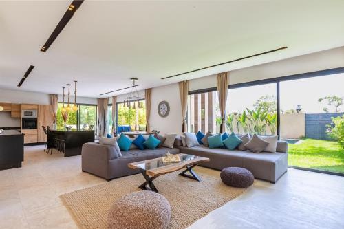 马拉喀什Villa Nounja Golf Amelkis Marrakech的客厅配有沙发和桌子
