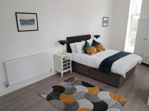 伍尔弗汉普顿Kingdom apartments的一间卧室配有一张大床和地毯。