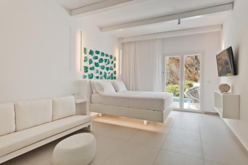 卡尔帕索斯Enilion Luxury Suites的白色的客厅配有床和沙发