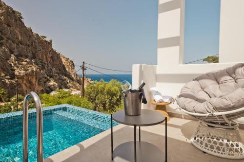 Kyra PanagiaEnilion Luxury Suites的别墅 - 带游泳池、椅子和桌子