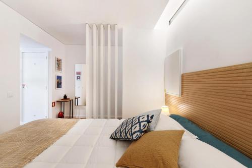 埃斯托利尔Estoril Art and Surf的一间卧室配有一张大床和木制床头板