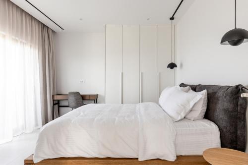 古瓦伊NOLA - Nomadic Luxury Villas的白色卧室配有床和沙发