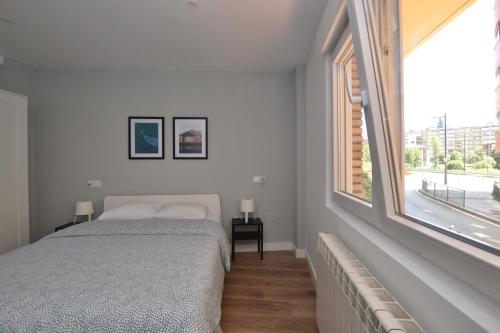 奥维多STAY Las Segadas的一间卧室设有一张床和一个大窗户