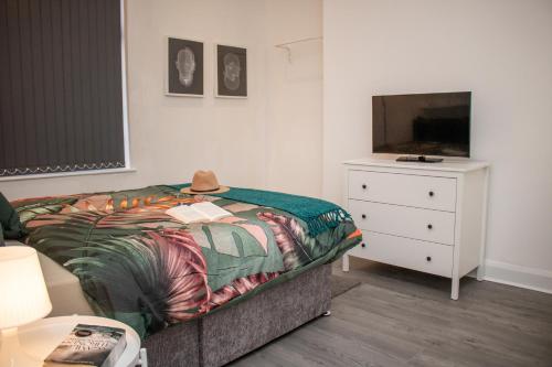 安特里Warm and relaxing hideaway的一间卧室配有一张床、梳妆台和电视。