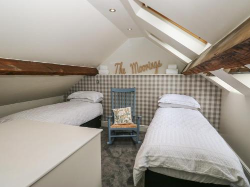 韦克菲尔德The Moorings的小型客房配有两张床铺和椅子