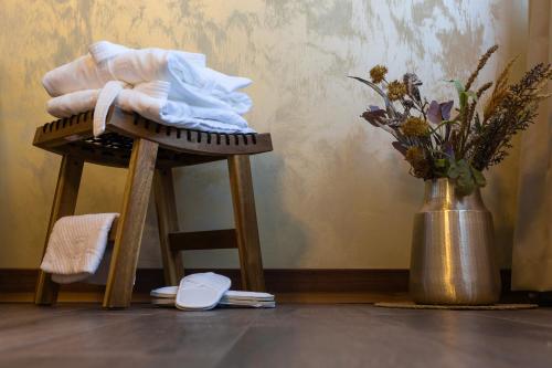 普利特维采湖格兰德湖酒店的花瓶旁的木凳和毛巾