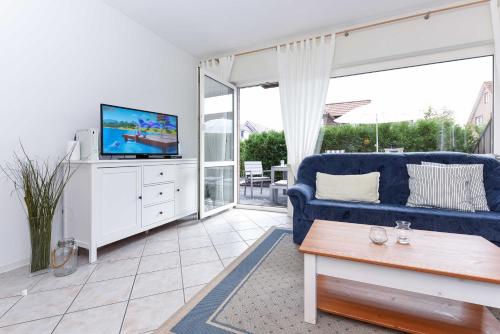贝塞尔Ferienwohnung Bensersiel Ahoi的客厅配有蓝色的沙发和电视