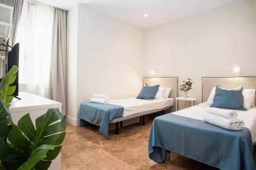 萨拉戈萨AZ Orús Factory Hotel - Parking Gratuíto的蓝色和白色的客房内的两张床