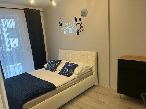 卡利什Apartament Korczak Park的卧室配有一张床,墙上挂着一个钟