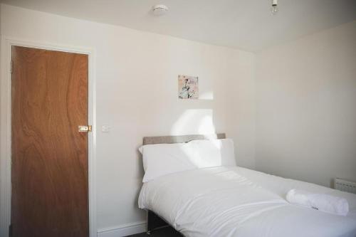 莱斯特Luxury City Rooms in Leicester的卧室配有白色的床和木门
