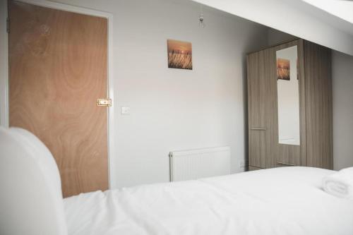 莱斯特Luxury City Rooms in Leicester的卧室配有白色的床和镜子