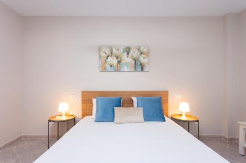 坎德拉里亚Home2Book Attic Terrace Apt Charming Ocean View的卧室配有带蓝色枕头的大型白色床